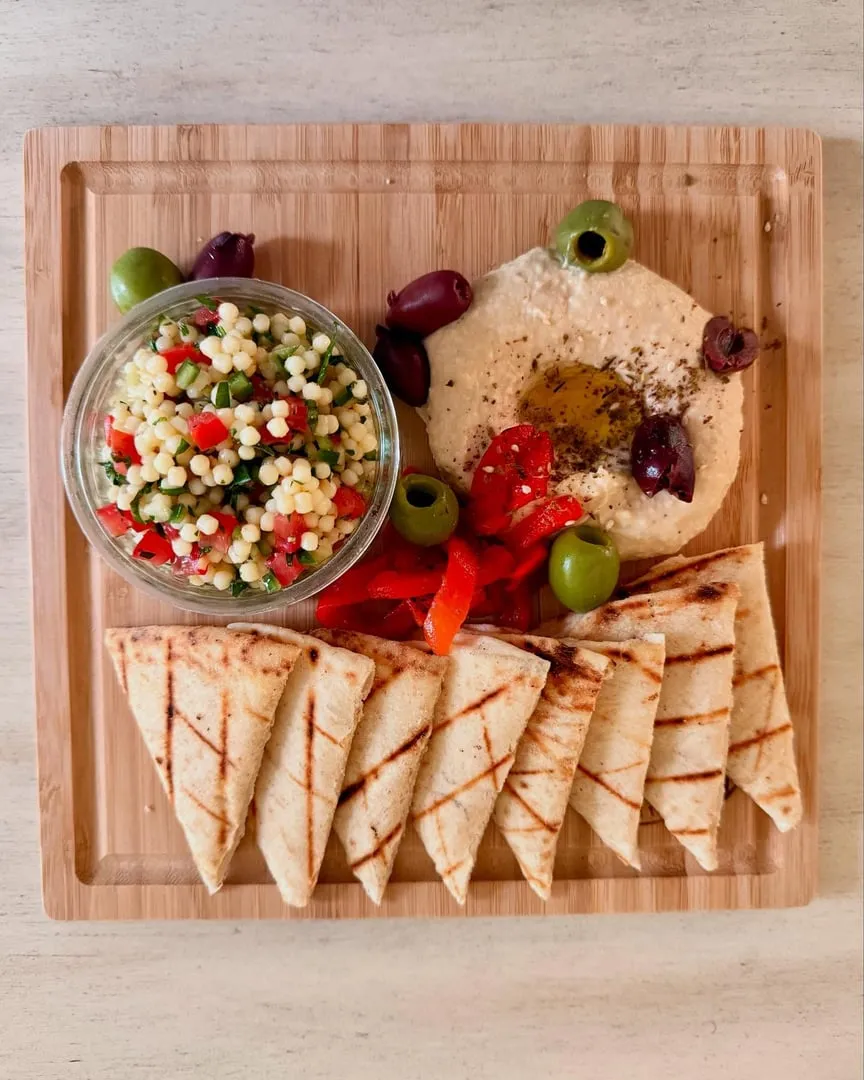 A mezze board with hummus, salad and grilled pita