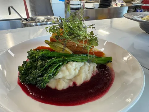 Seasonal Salmon: pan-seared salmon over mashed potatoes and beet reduction, with broccolini